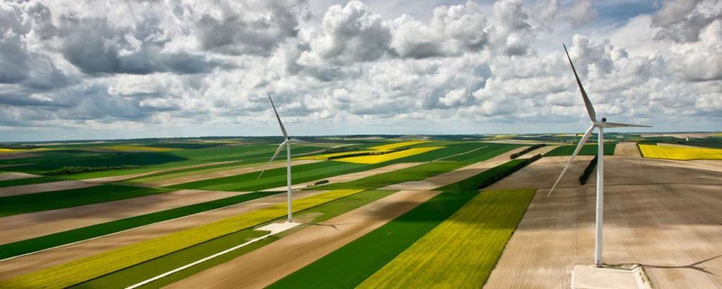 Green field clouds sky wind turbines