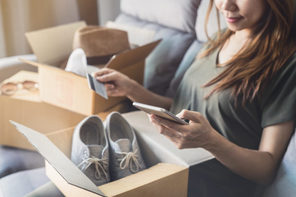 Adobe Stock vrouw opent doos met daarin schoenen die zij online bestelde