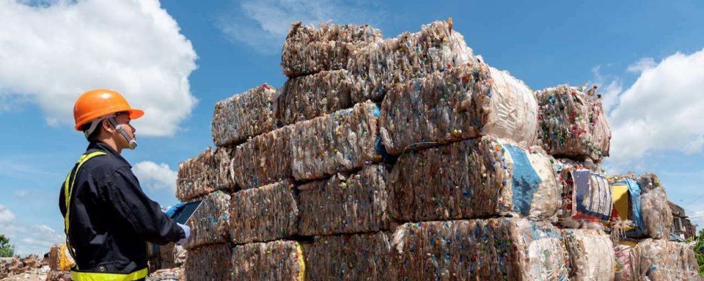 Recycling balen afval met medewerker