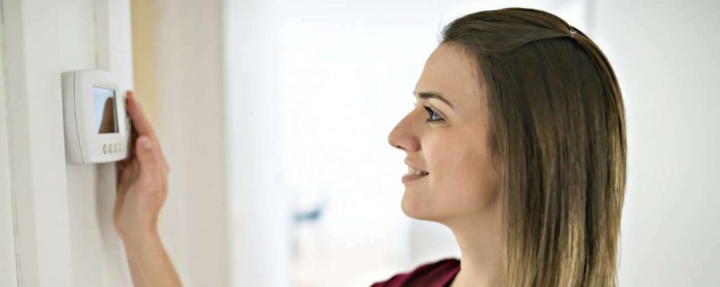 Vrouw zet de thermostaat lager