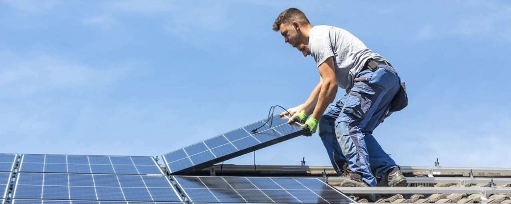 Installatie zonnepaneel op dak door mannen