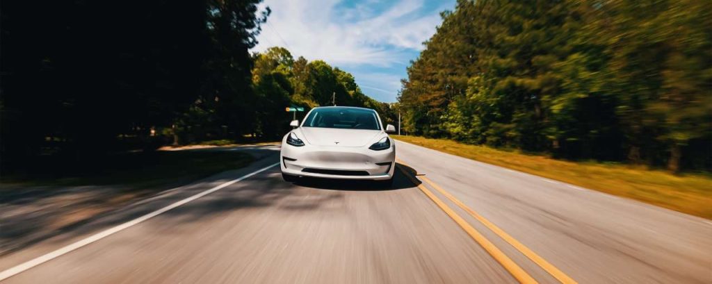 Tesla model 3 op de weg adobestock
