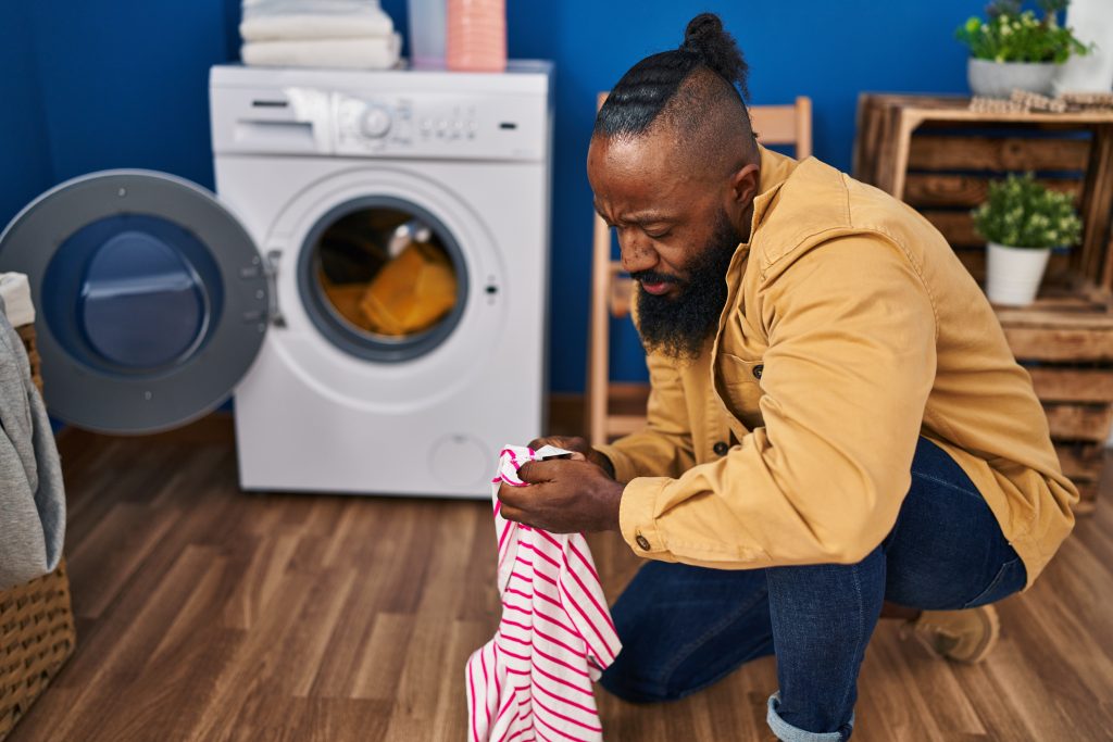 Adobe Stock man sorteert kleding voor wasmachine