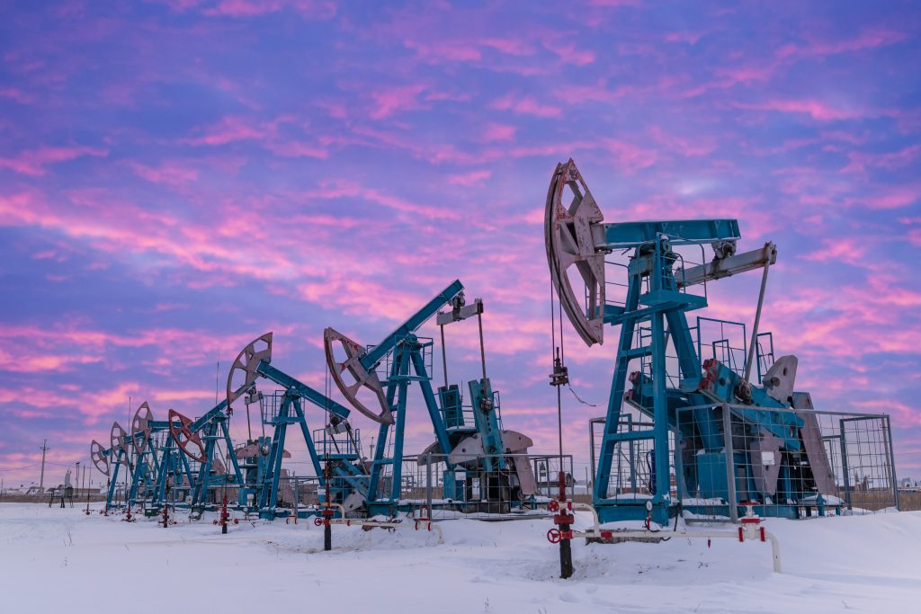 Adobe Stock olie machines in een winterlandschap met een paarse lucht