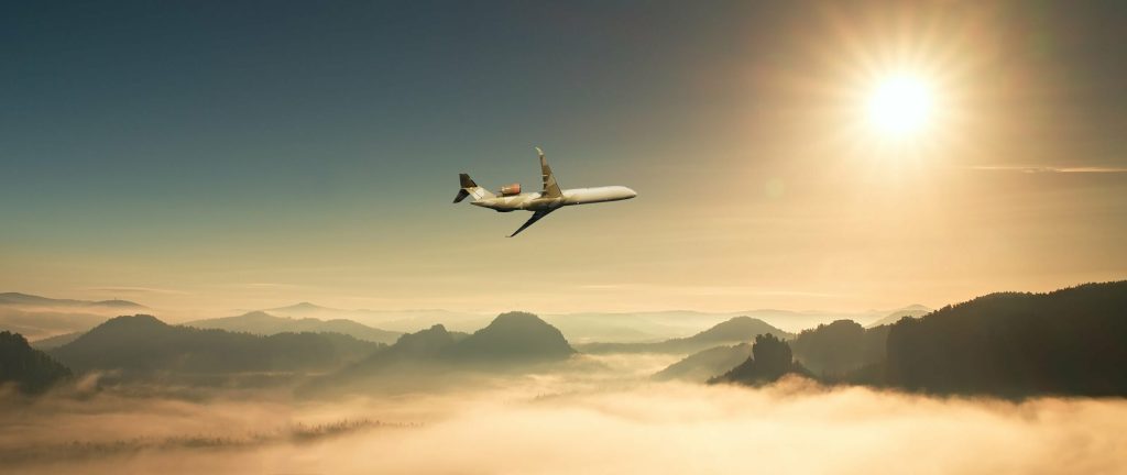 Fokker next gen clean aviation over mountains in morning dew