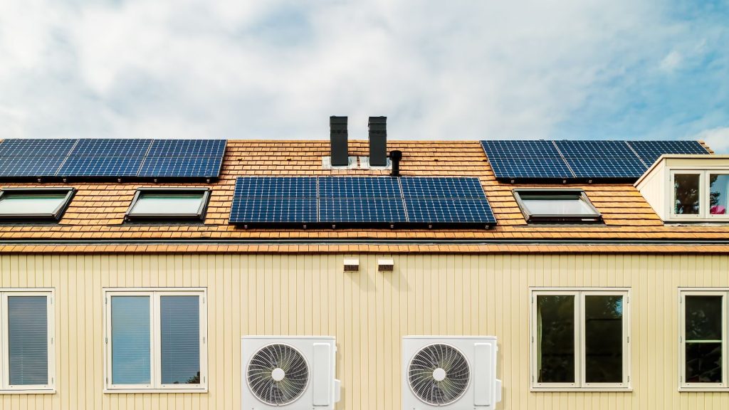 Row of new Dutch houses with solar panels and air-source heat pumps