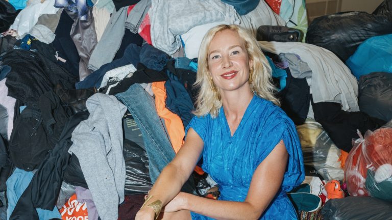 VNYX-medeoprichter Romy Goedhart op één van de bergen textiel bij Milieuwerk in Amsterdam